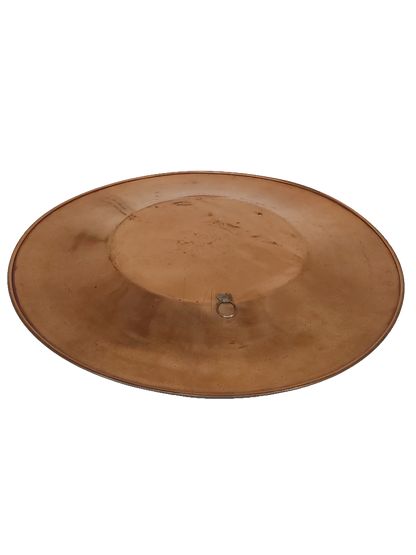 Plate lying at an angle, showing its shallow curved profile, a raised rim, and the metal hanging loop on the back.