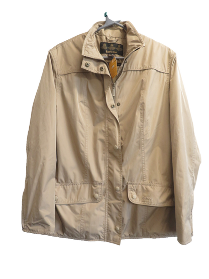 Front of the beige jacket on a hanger, showing the high collar, snap-fastened front, and two pockets with snap flaps.
