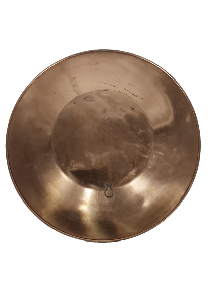 Back of the plate, plain polished copper with a small metal loop hanger fixed at the centre and a few light scratches visible.