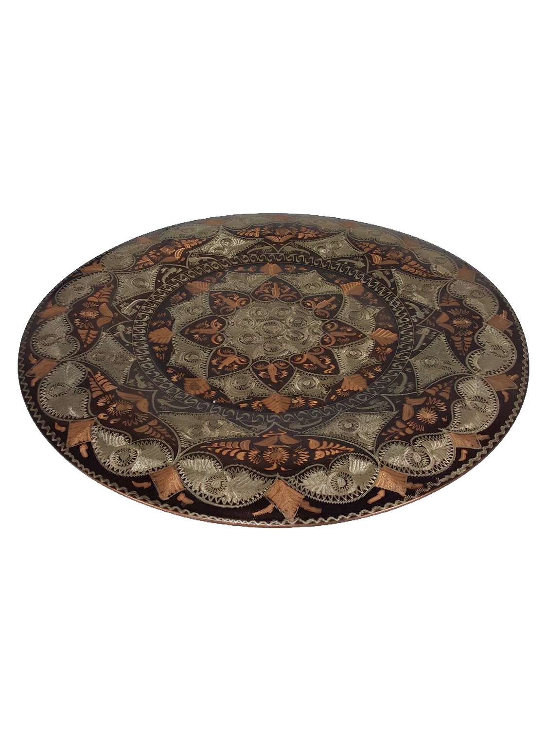 Front of the plate photographed at an angle, showing the curved surface and the etched pattern around the outer rim.